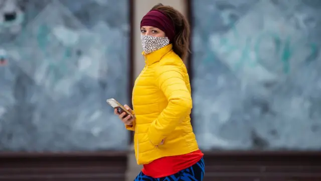 Woman walking past boarded up shop