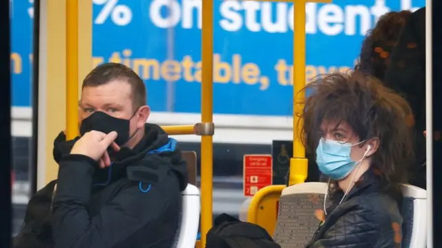 People wear protective masks as they ride on a tram, amid the outbreak of the coronavirus disease (COVID-19), in Manchester,