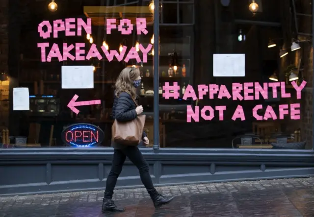 A woman walks past a cafe in Edinburgh