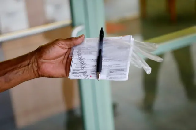 A hand holding a sample ballot pictured in Orlando, Florida, on October 19, 2020