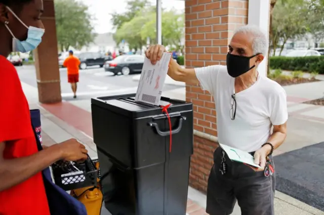 A man deposits his ballot at a polling station in Orlando, Florida