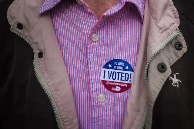 A man wears an "I Voted!" badge on the first day of early voting in Florida