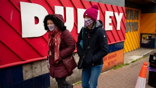 Shoppers wearing protective face masks walk along High Street, Dudley