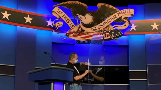 Man cleaning plexiglass ahead of the debate in Nashville