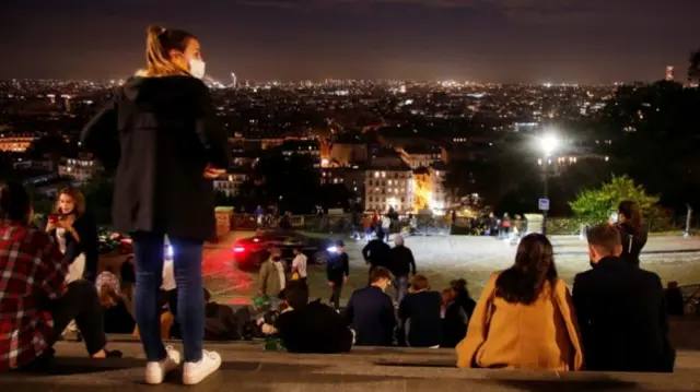 People enjoy the view from Montmartre few minutes before the nightly curfew due to restrictions against the spread of the coronavirus disease