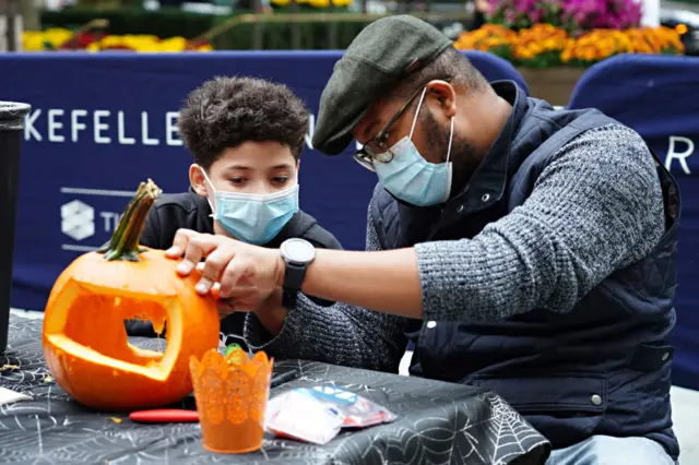 Halloween pumpkins are carved in New York City, where face masks are required