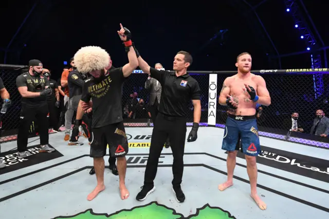 Khabib Nurmagomedov's arm is held aloft after beating Justin Gaethje