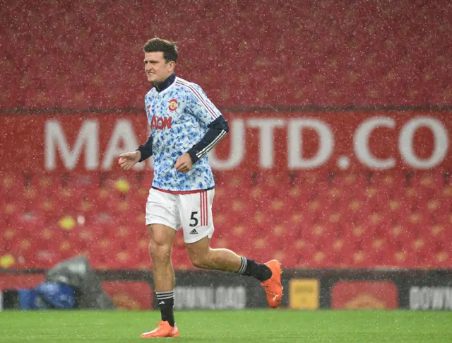 Harry Maguire warms up in the rain