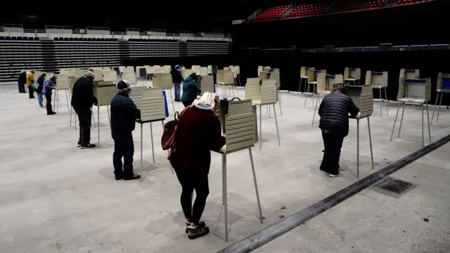 Voters complete their ballots at socially distanced privacy booths at a early voting site inside the Bismarck Event Center as the coronavirus disease (COVID-19) outbreak continues in Bismarck, North Dakota, 26 October, 2020.