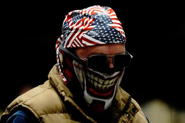 A voter wearing an U.S. flag bandanna and a Joker face covering checks in at a early voting site inside the Bismarck Event Center as the coronavirus disease outbreak continues in Bismarck, North Dakota.