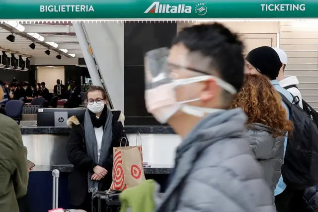 Travellers wearing masks at an airport in New York (file photo)