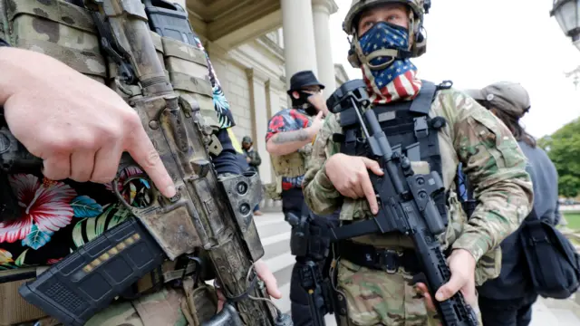 A group tied to the Boogaloo Bois holds a rally as they carry firearms at the Michigan State Capitol in Lansing, Michigan on October 17, 2020.