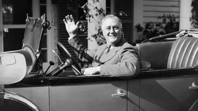 President Franklin D Roosevelt waves from his car at Warm Springs, Georgia in 1935