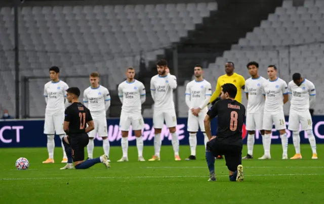 Manchester City players take the knee as Marseille players watch on