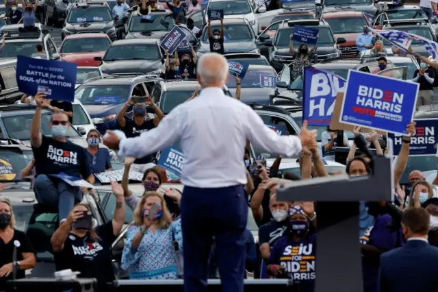 Biden campaigns in Georgia against a backdrop of cars