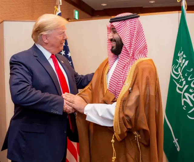 Trump shakes hands with Saudi Arabia's Crown Prince Mohammed bin Salman, wearing a red tie