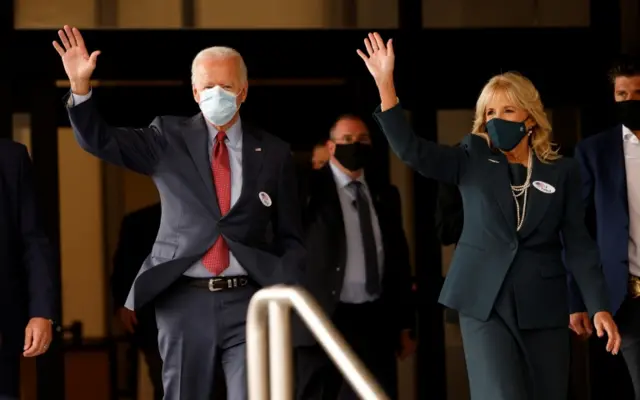 Joe Biden and his wife wave after casting their votes