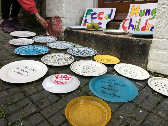 Plates with anti-child food poverty slogans written on them