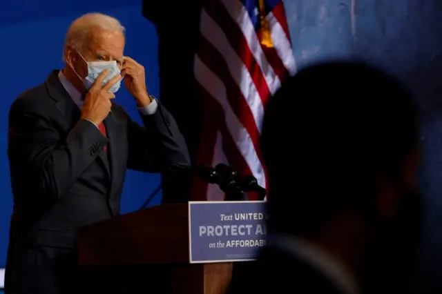 Biden puts his mask back on after speaking