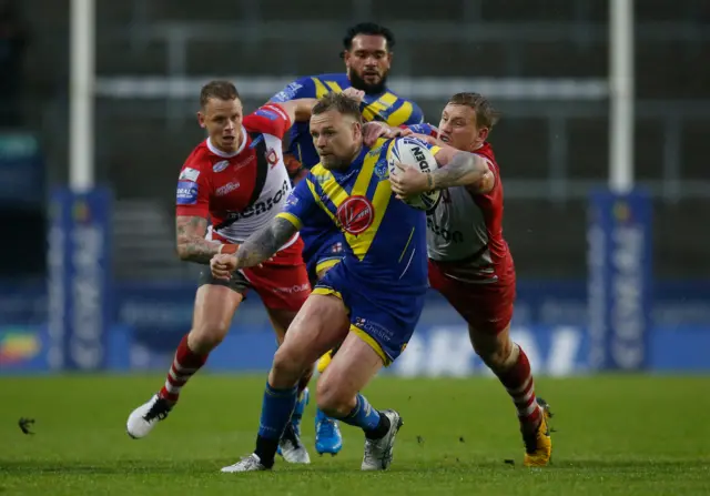 Warrington Wolves' Blake Austin and Salford Red Devils' James Greenwood in action