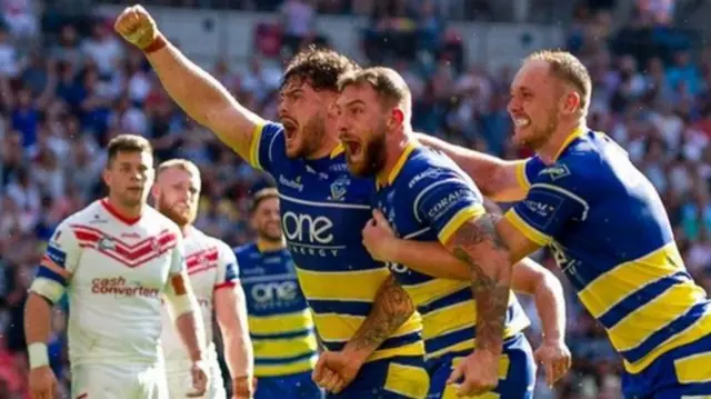 Daryl Clark (centre) celebrates his try, which helped him secure the Lance Todd Trophy as man of the match