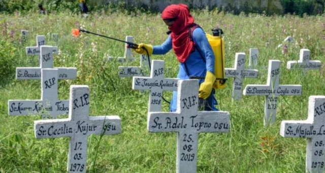 A municipal worker sanitises a graveyard in India after the burial of Covid victims. File photo