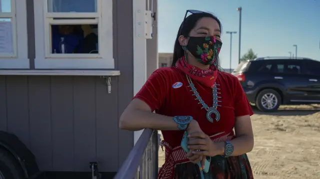 A woman leans on a railing in the Navajo Nation