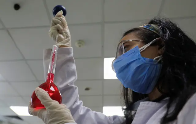 A pharmacist doctor works on the basics of the raw materials for investigational of the coronavirus disease (COVID-19) treatment drug Remdesivir