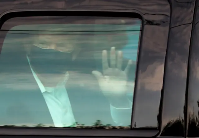 Donald Trump waves as he drives past supporters outside the Walter Reed National Military Medical Center