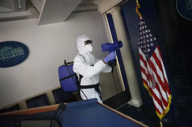 Workers sanitise the White House press briefing room