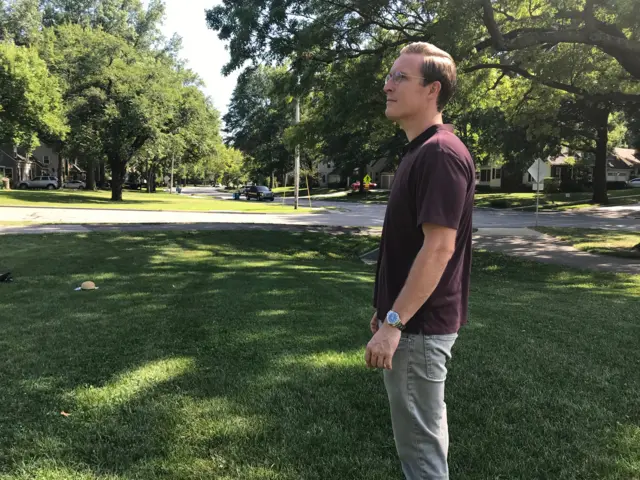 Neil Melton stands in a yard