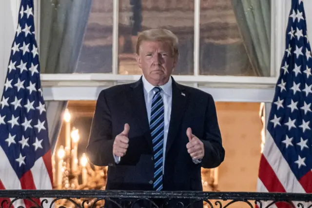 Trump gestures after returning to the White House