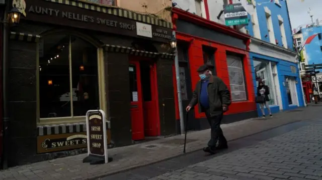 An elderly man wearing a mask walks in Galway, Ireland