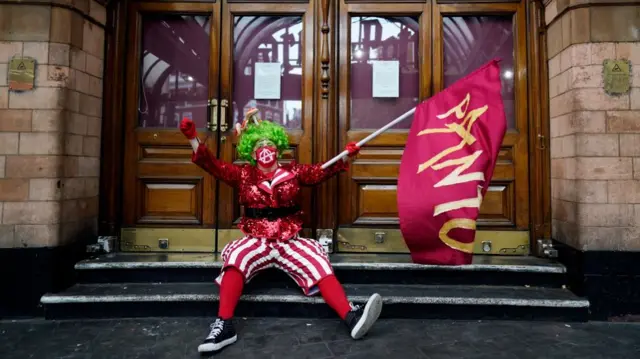 A Pantomime dame sits outside a closed theatre during a demonstration with other dames and theatre professionals held to demand more support for the arts and theatre sector amid the Covid-19 coronavirus pandemic