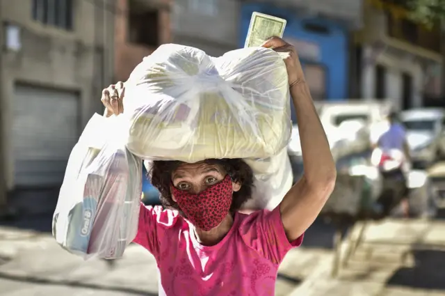 A woman, a poor resident of the Serra Aglomerado Favela, receives food supplies