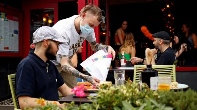 A restaurant waiter wearing a mask