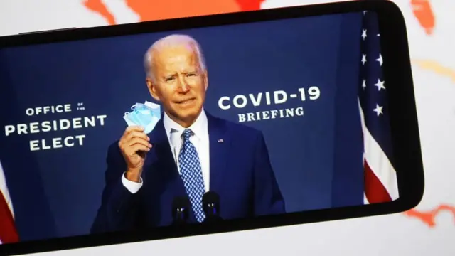 Joe Biden holds a face mask