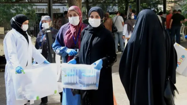 Nurses from the Great Prophet Hospital of Hezbollah carry blood samples in the southern suburbs of Beirut