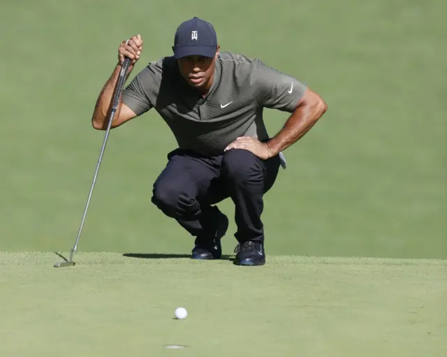 Tiger Woods eyes up putt.