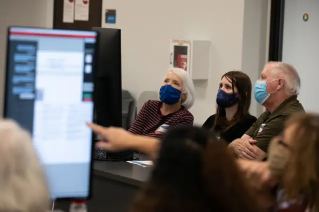 Members of the Gwinnett County adjudication review panel look over remaining scanned ballots at the Gwinnett Voter Registrations and Elections office on November 8, 2020 in Lawrenceville, Georgia