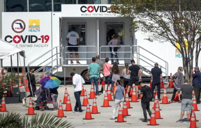 People wait outside a testing centre in Florida