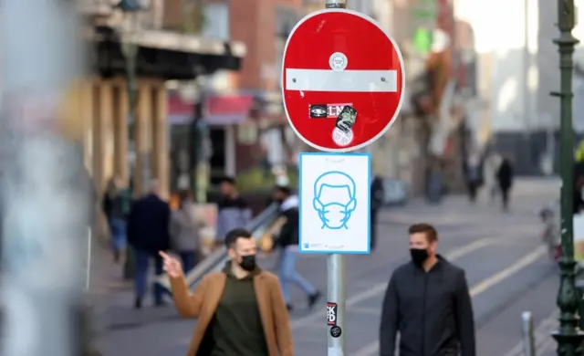 A sign in Dusseldorf reminds people to wear a face mask