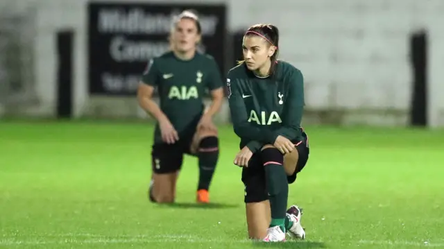 Alex Morgan takes a knee