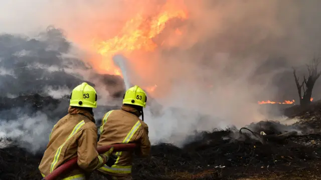 Firefighters work to put out the fire on the ground