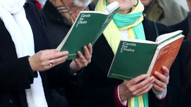 Two people singing Christmas carols