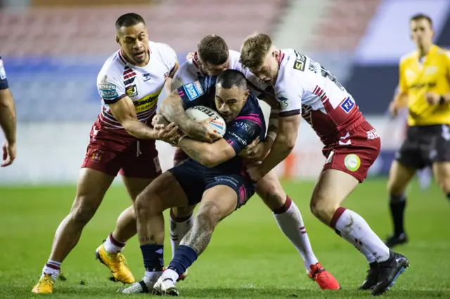 Mahe Fonua of Hull FC is tackled by Willie Isa and Morgan Smithies of Wigan