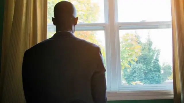 Man staring out of window