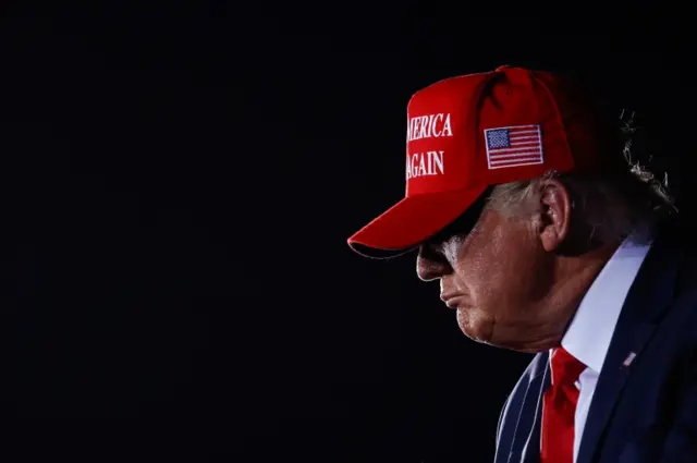 Donald Trump wears a MAGA hat at a campaign rally in Florida