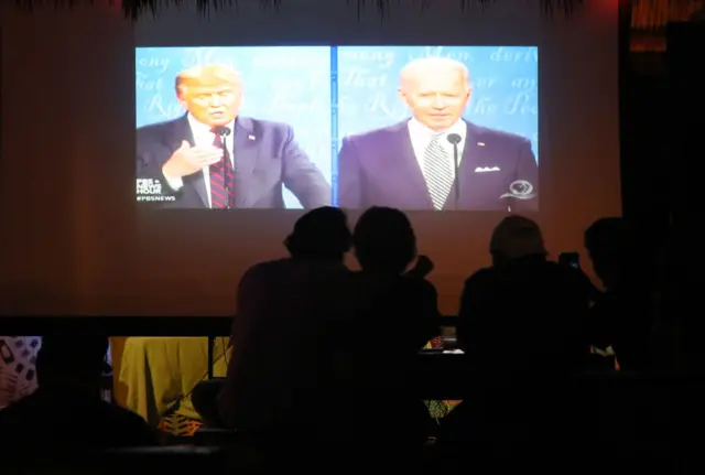 People watch the first presidential debate between Donald Trump and Joe Biden on September 29, 2020 in Miami, Florida