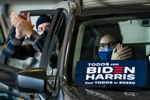 Supporters cheer from their cars